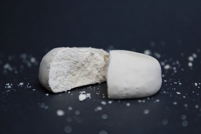A detailed close-up of a split polvoron, showcasing texture against a black background.
