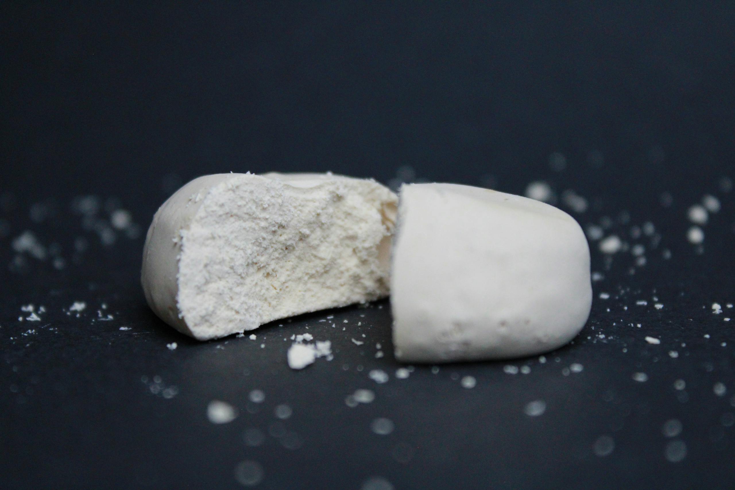 A detailed close-up of a split polvoron, showcasing texture against a black background.