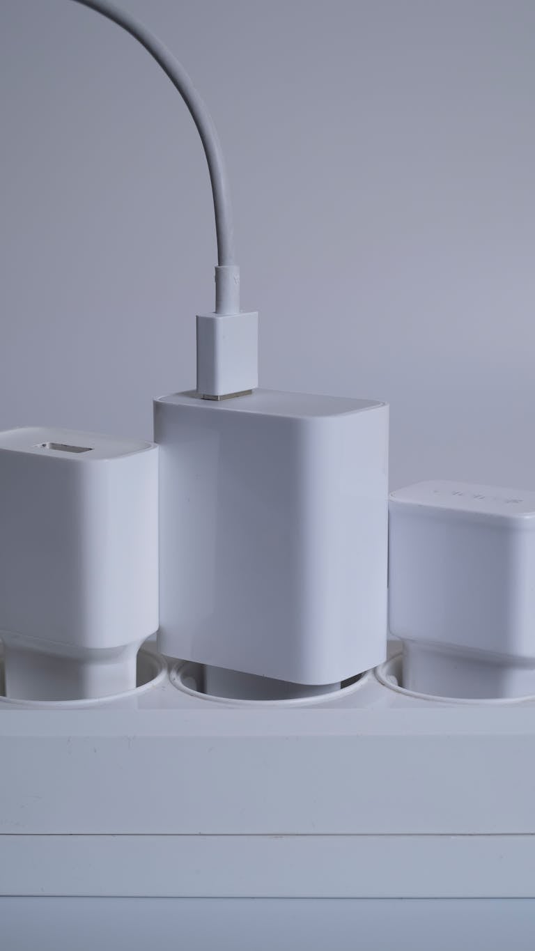 Contemporary white power adapters arranged neatly on a power socket bar.