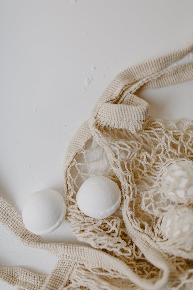 Organic bath bombs displayed in a natural mesh bag for sustainable living.