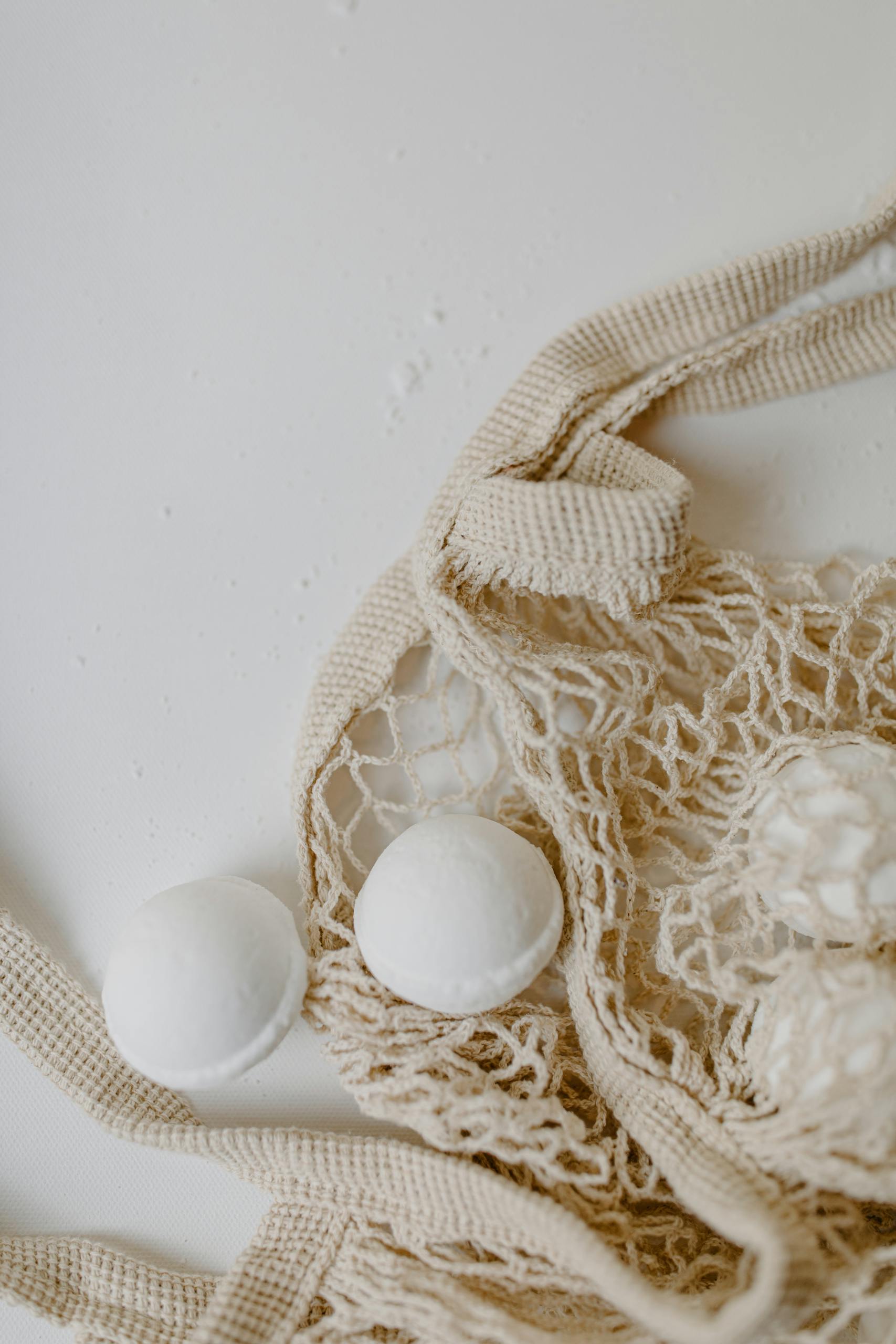 Organic bath bombs displayed in a natural mesh bag for sustainable living.