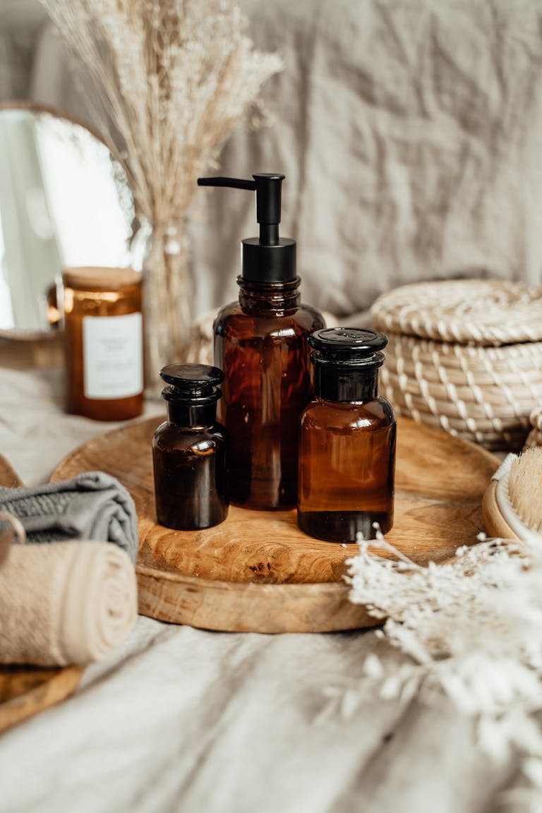 Stylish arrangement of brown glass aromatherapy bottles with natural decor in a soft indoor setting.