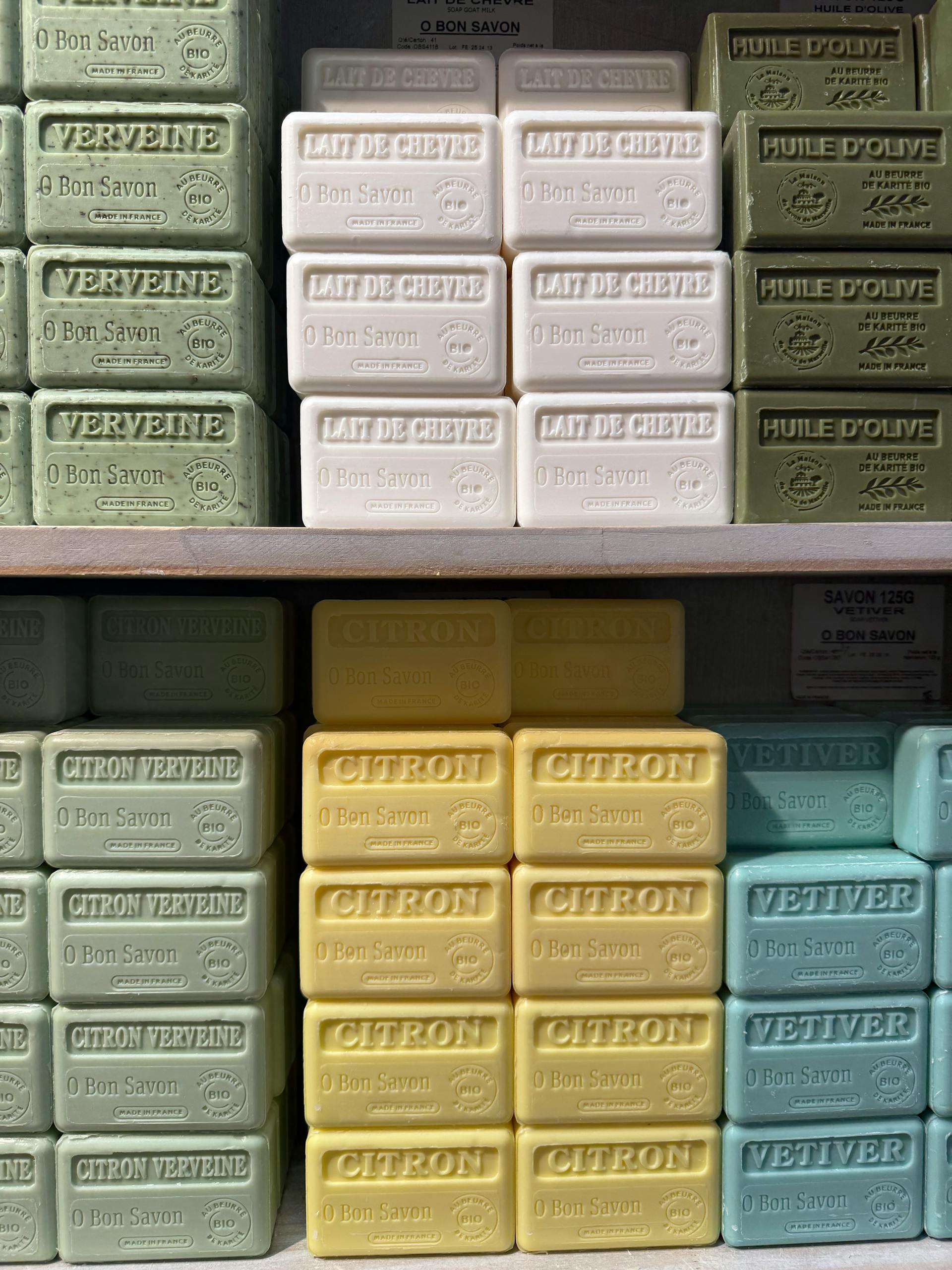 Various scented soap bars arranged neatly on shelves in a store display.