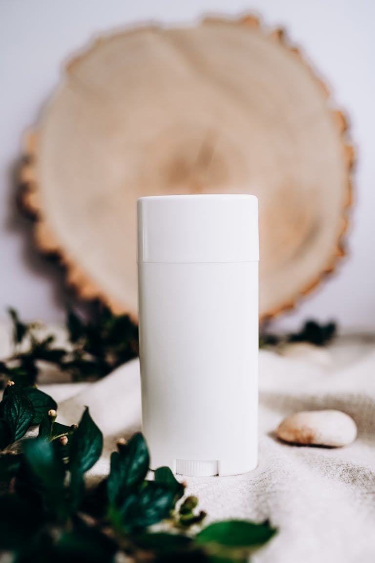 White scent diffuser surrounded by fresh leaves, enhancing natural ambiance.